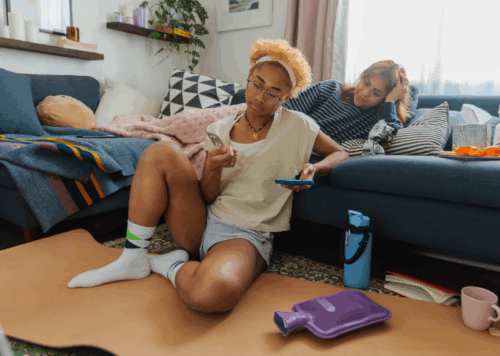 Two people look at pill pack on the couch.